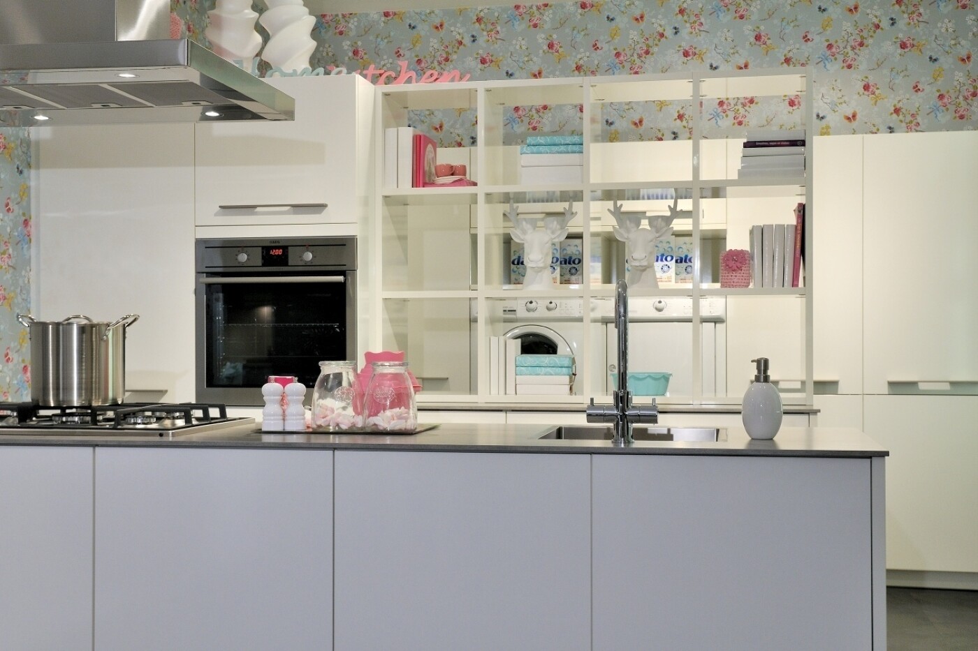 Die freistehende Theke, grifflos und matt lackiert, schafft eine ruhige Barriere zum Küchenbereich. Die freistehende Theke, grifflos und matt lackiert, schafft eine ruhige Barriere zum Küchenbereich.